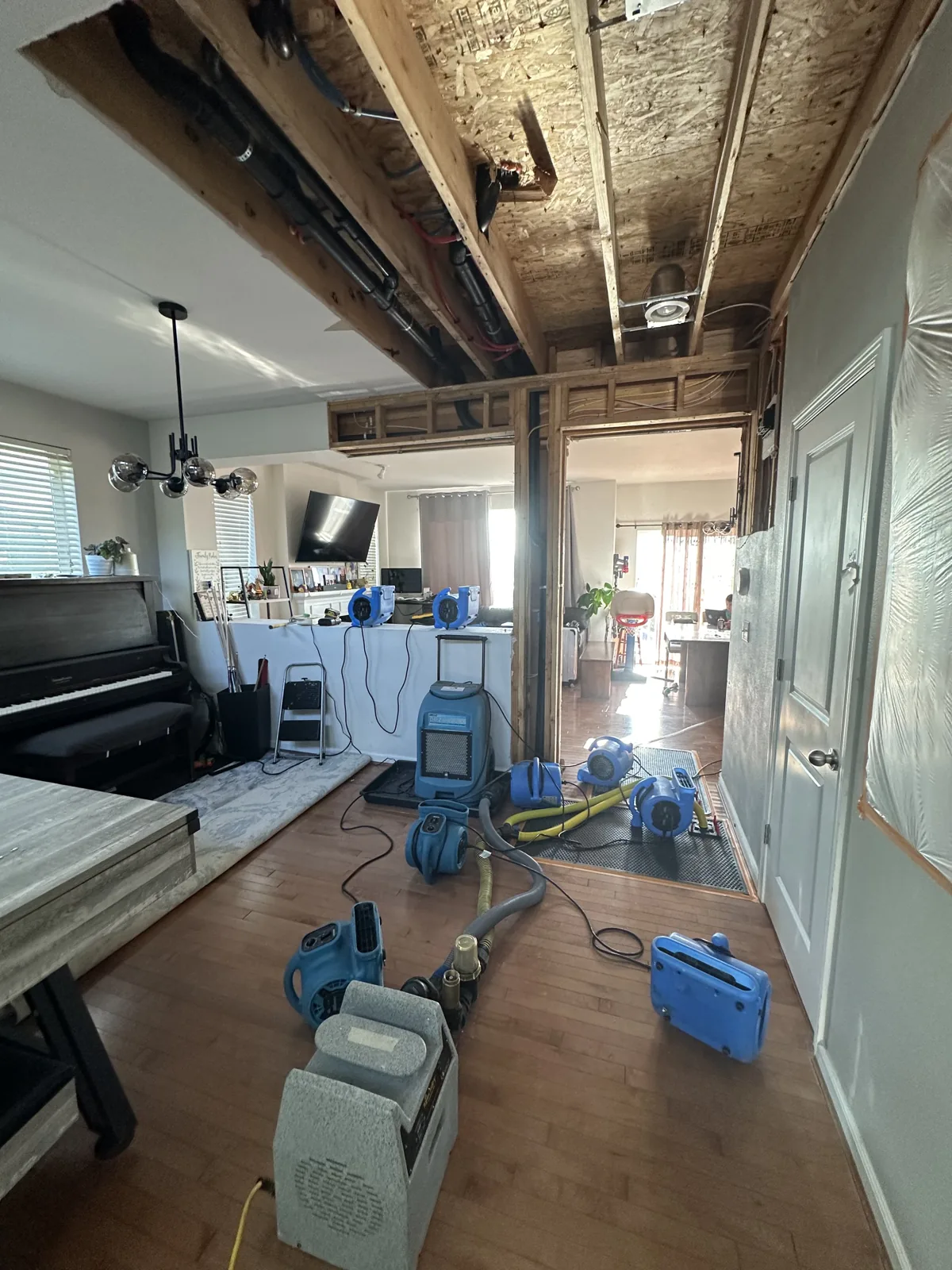 Mercer Island: Exposed ceiling framing and drying equipment in the affected living area.